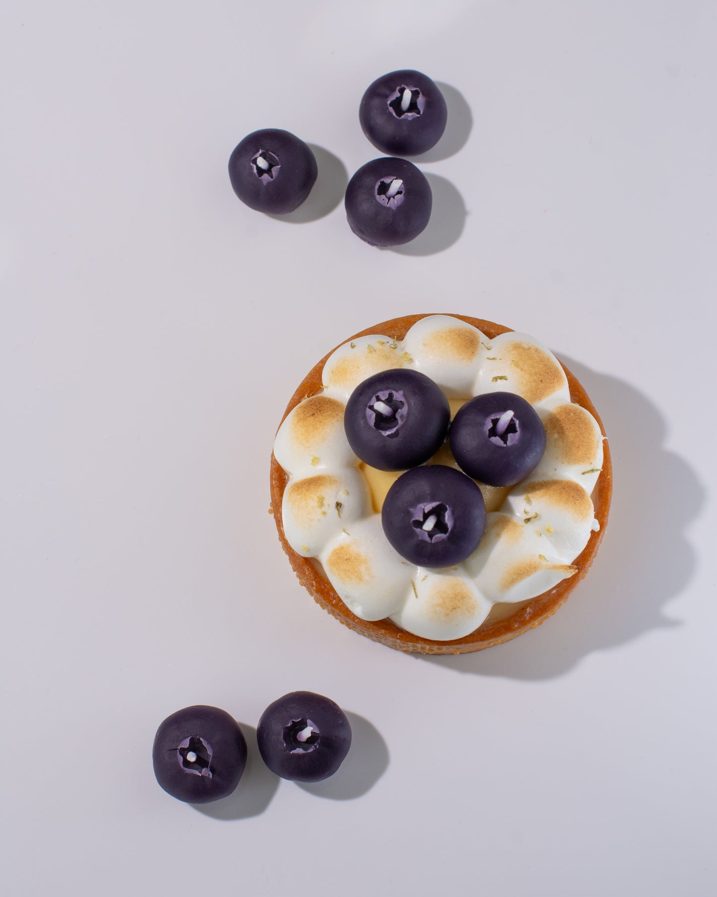 Handmade beeswax candle mimicking real blueberries
