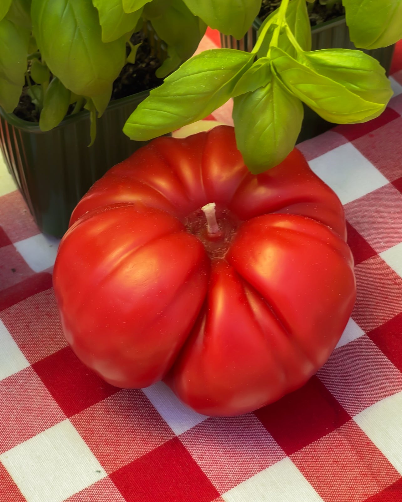 Realistic tomato-shaped beeswax candle with natural red finish