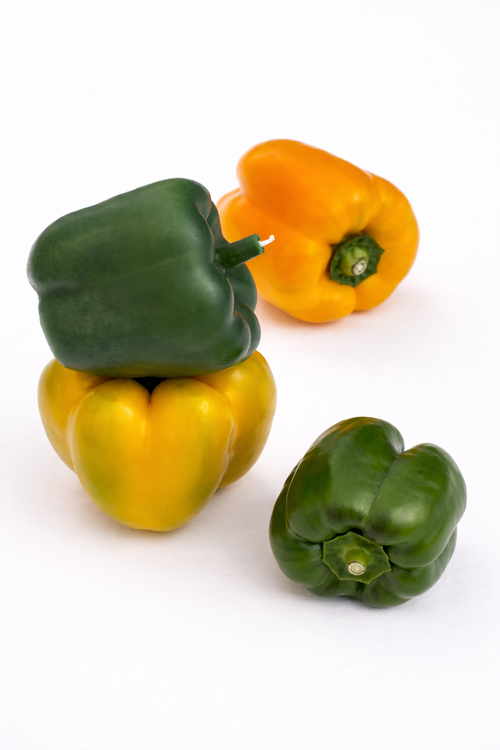 Four bell peppers candles in green and yellow on a white background