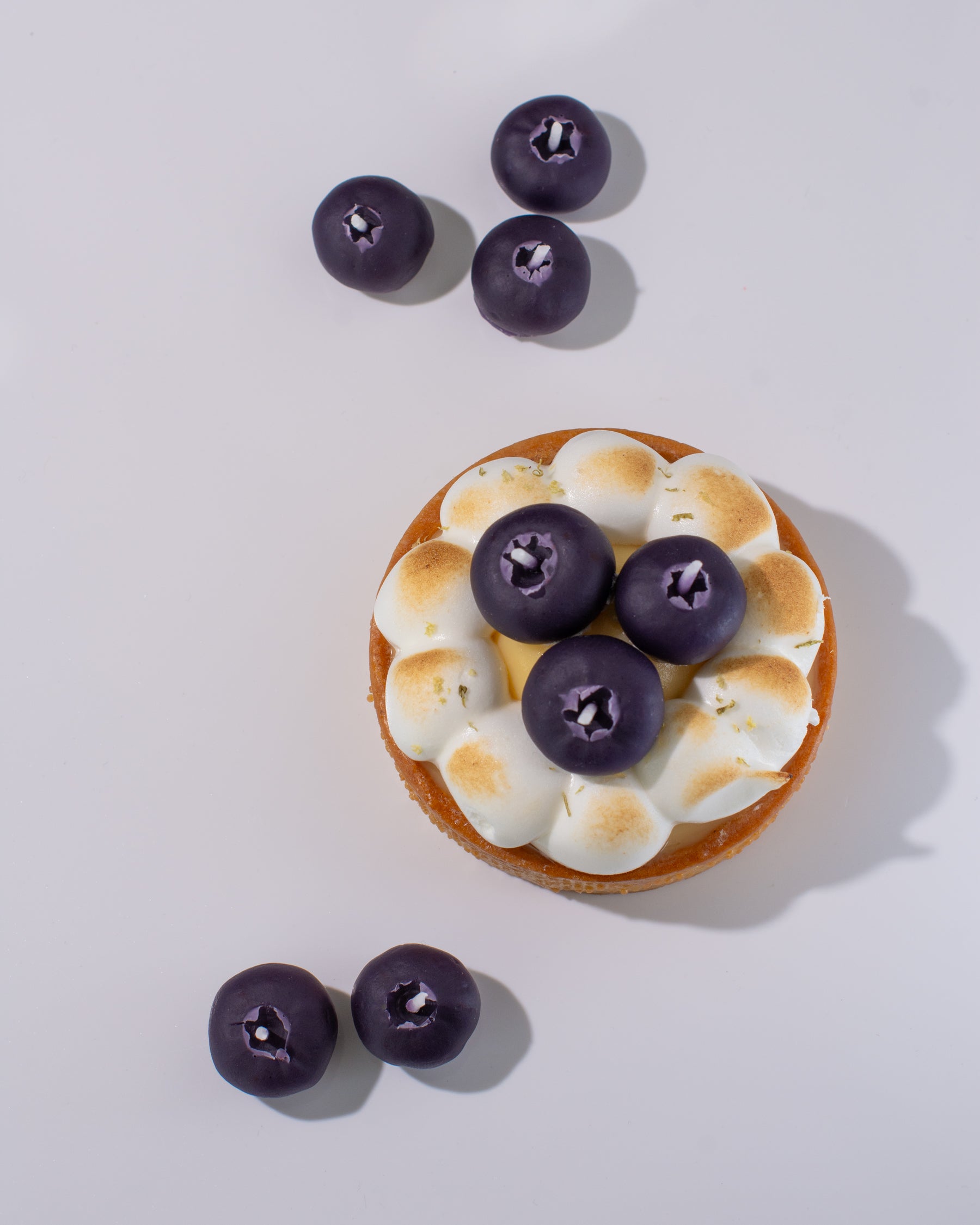 Handmade beeswax candle mimicking real blueberries